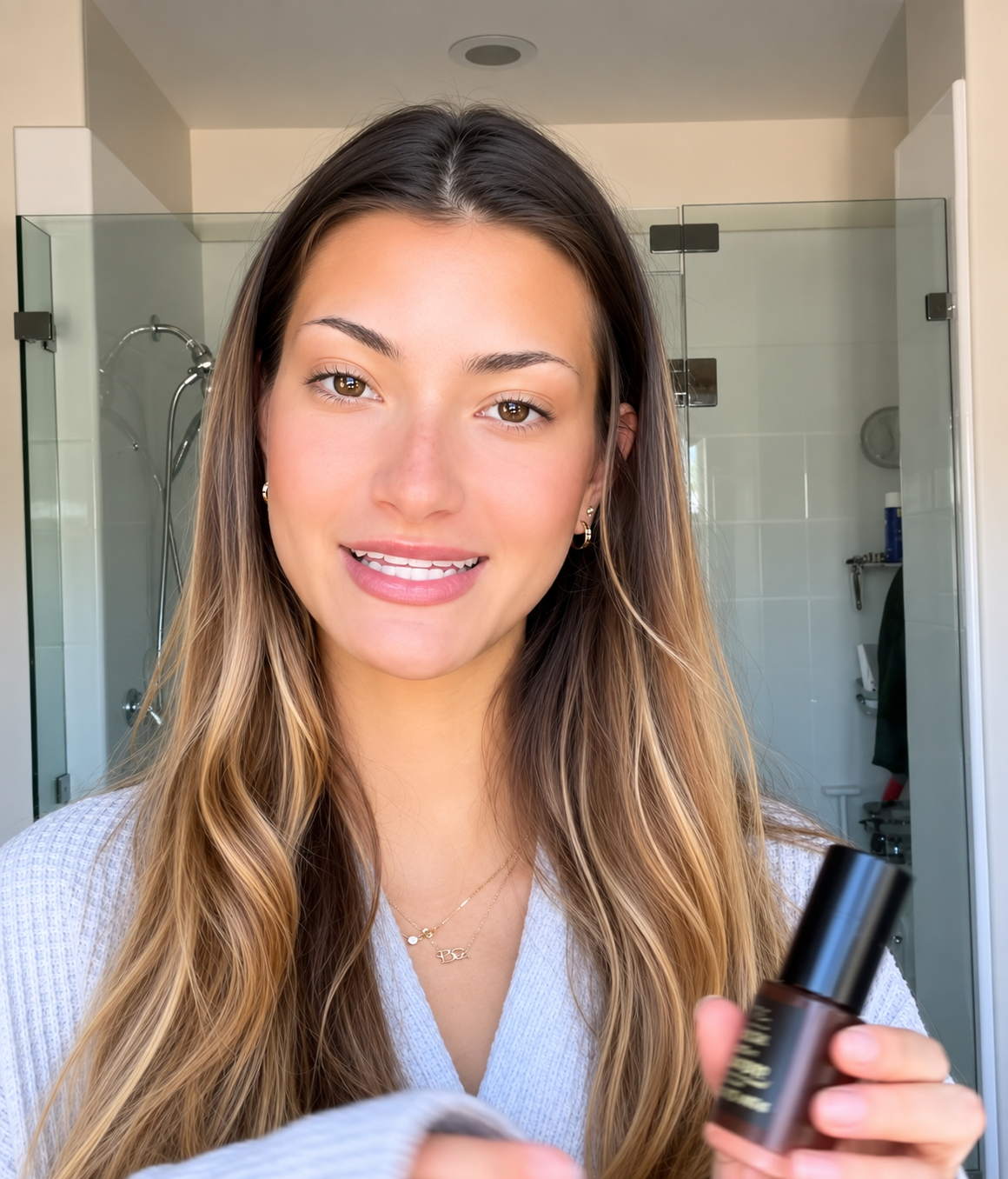 Woman holding a cosmetic product in a bathroom setting